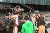 The docent from The Antiquities and Monuments Office narrating the history of the lions of the Hong Kong and Shanghai Bank (now HSBC) to the participants